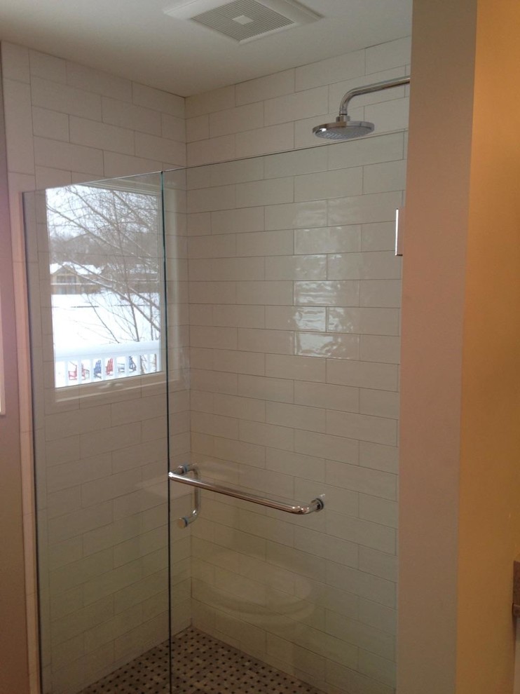 Cette image montre une douche en alcôve principale de taille moyenne avec un carrelage métro, un mur blanc, parquet peint, un sol blanc et une cabine de douche à porte battante.