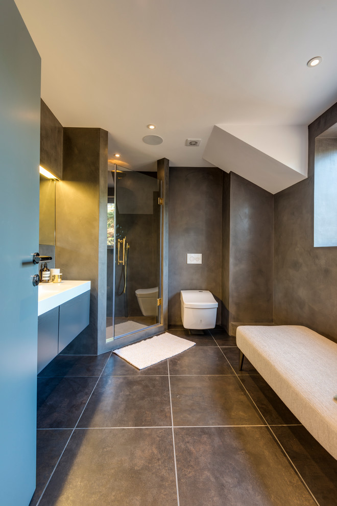 Immagine di una stanza da bagno design con doccia ad angolo e pareti grigie
