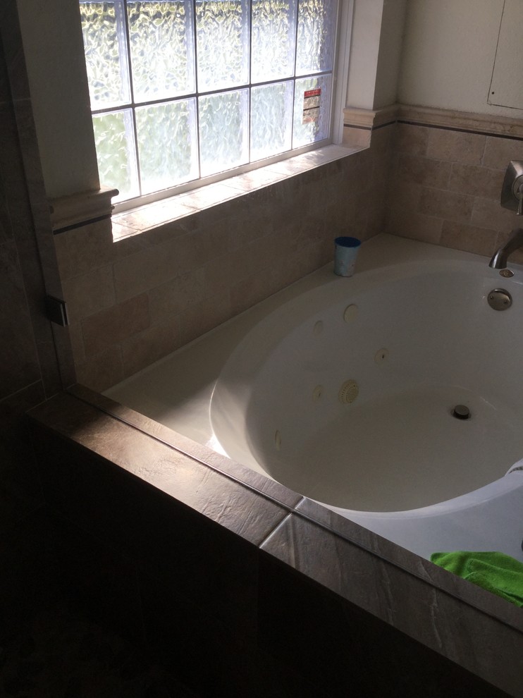 Idée de décoration pour une petite salle de bain principale tradition avec une baignoire posée, une douche d'angle, un carrelage beige et une plaque de galets.