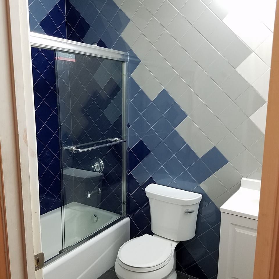 Idéer för ett mellanstort klassiskt badrum, med möbel-liknande, vita skåp, ett badkar i en alkov, en dusch i en alkov, en toalettstol med separat cisternkåpa, blå kakel, keramikplattor, grå väggar, klinkergolv i keramik, bänkskiva i kvarts, blått golv och dusch med skjutdörr