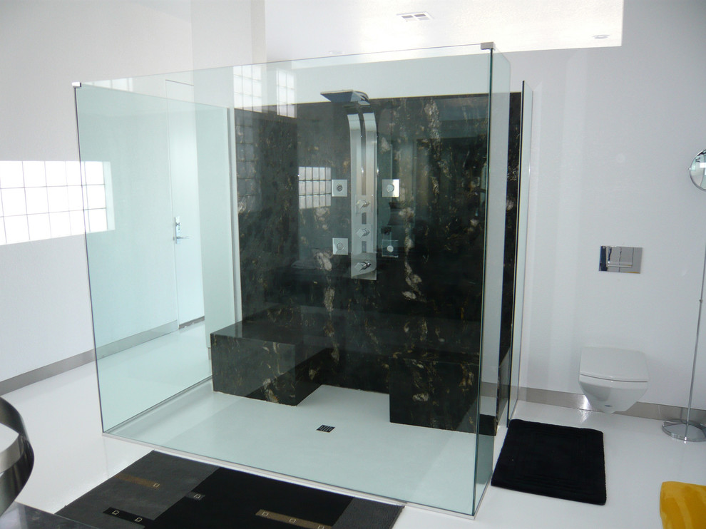Cette photo montre une salle de bain principale chic de taille moyenne avec une douche à l'italienne, WC suspendus, un carrelage noir et blanc, un carrelage marron, des dalles de pierre, un mur blanc et sol en stratifié.