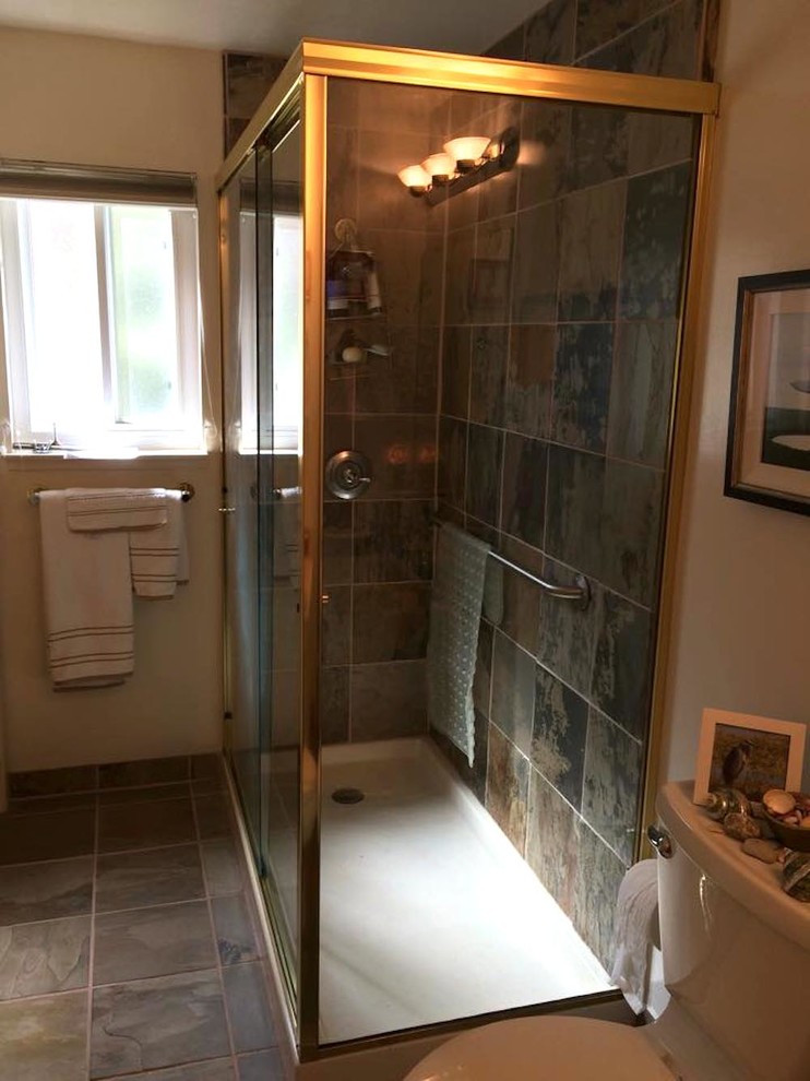 Foto på ett mellanstort vintage badrum, med luckor med infälld panel, vita skåp, en hörndusch, en toalettstol med separat cisternkåpa, beige väggar, skiffergolv, flerfärgad kakel, skifferkakel, flerfärgat golv och dusch med skjutdörr