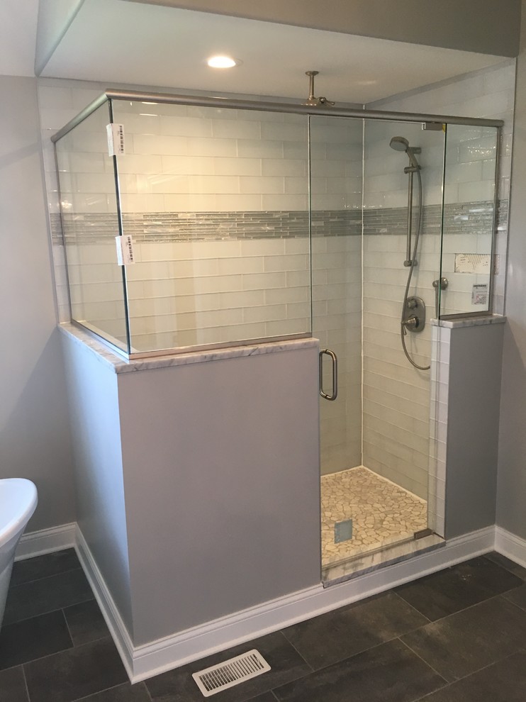 На фото: главная ванная комната среднего размера в классическом стиле с отдельно стоящей ванной, угловым душем, белой плиткой, стеклянной плиткой, серыми стенами, полом из керамогранита, коричневым полом и душем с распашными дверями