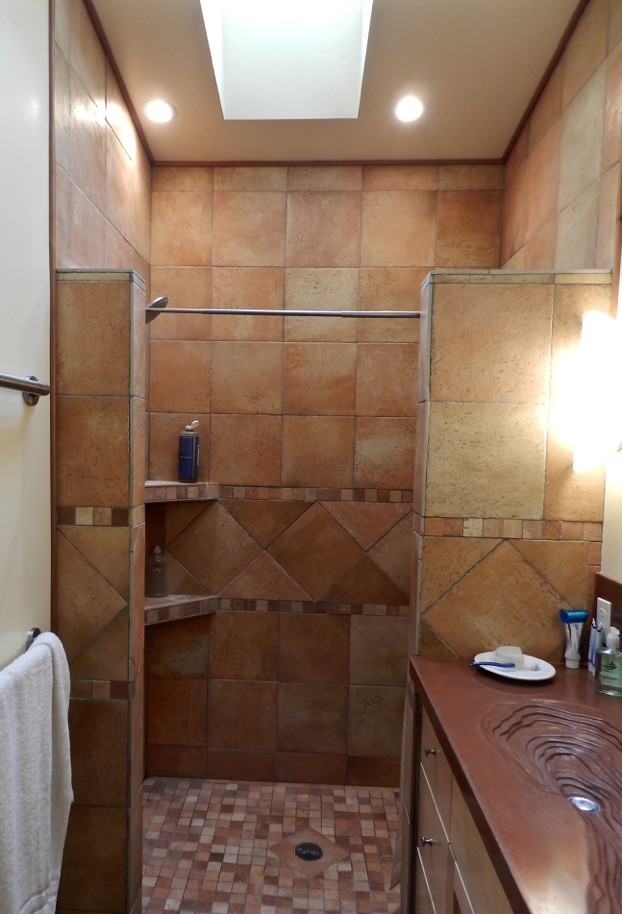 Exemple d'une douche en alcôve principale éclectique en bois clair de taille moyenne avec un placard à porte shaker, un carrelage marron, des carreaux de céramique, un mur beige, un sol en carrelage de céramique, un lavabo intégré et un plan de toilette en béton.