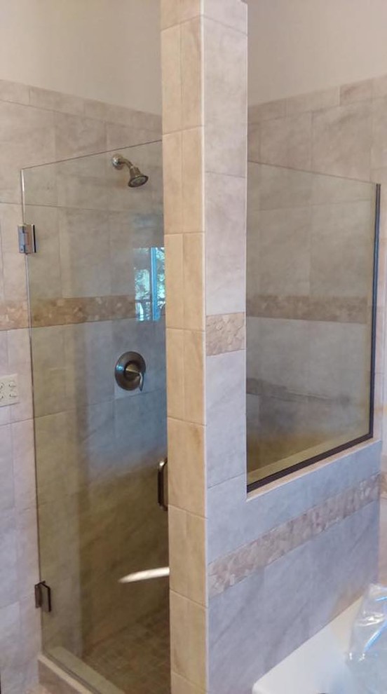 Ispirazione per una stanza da bagno con doccia tradizionale di medie dimensioni con doccia ad angolo, piastrelle beige, porta doccia a battente, piastrelle in ceramica e pareti beige