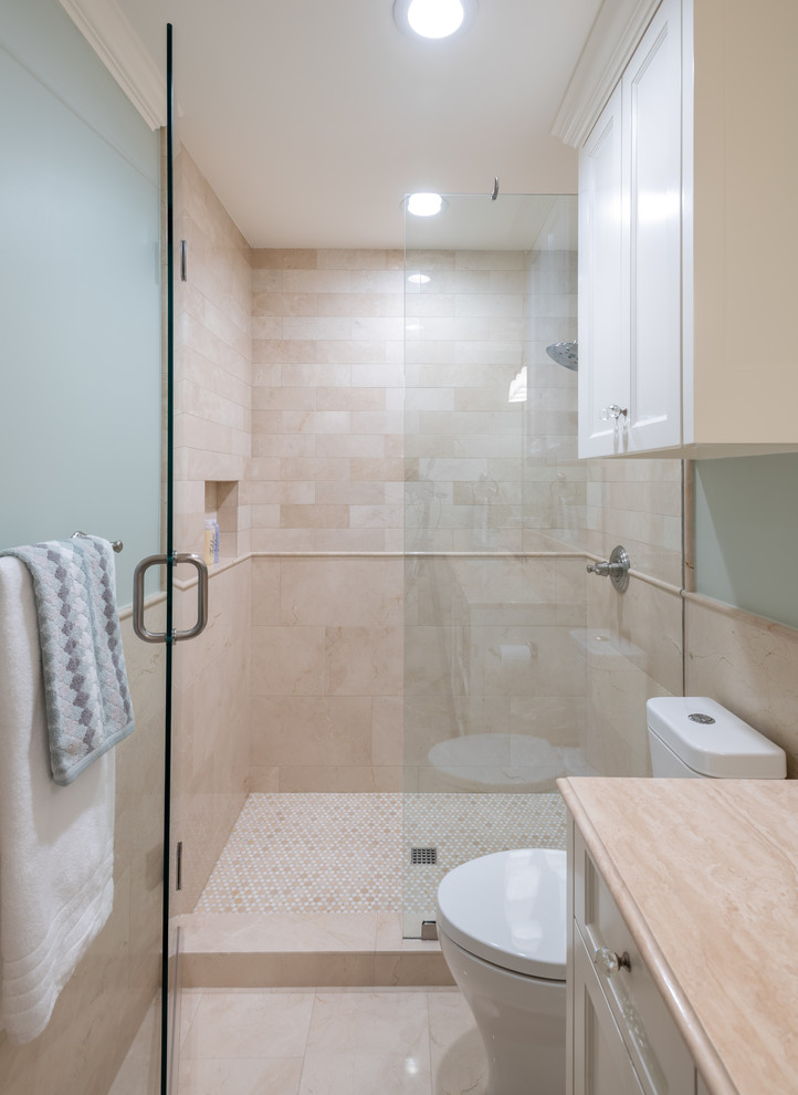 Example of a mid-sized classic kids' beige tile and marble tile marble floor and beige floor alcove shower design in Dallas with shaker cabinets, white cabinets, a two-piece toilet, green walls, an undermount sink, limestone countertops, a hinged shower door and beige countertops