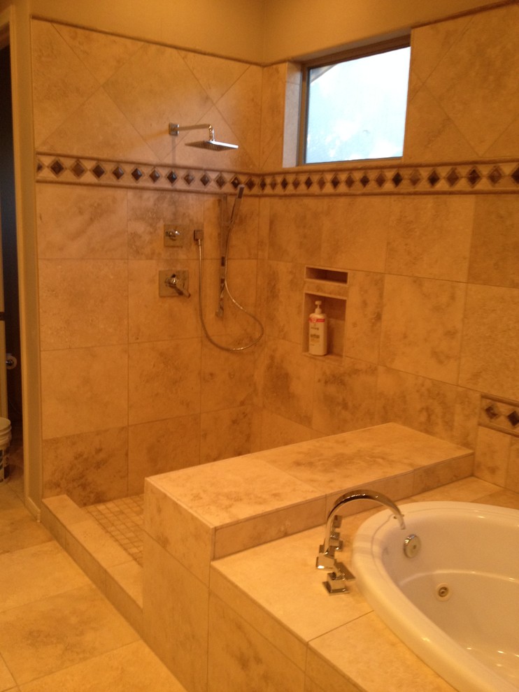 This is an example of a large traditional ensuite bathroom in Phoenix with recessed-panel cabinets, dark wood cabinets, a built-in bath, a corner shower, beige tiles, brown tiles, stone tiles, beige walls, travertine flooring, a submerged sink and granite worktops.