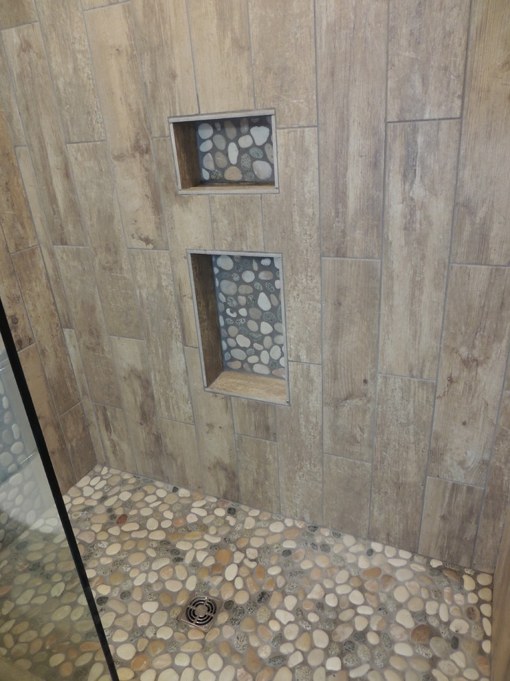 Esempio di una piccola stanza da bagno design con piastrelle marroni, piastrelle di ciottoli e pavimento con piastrelle di ciottoli