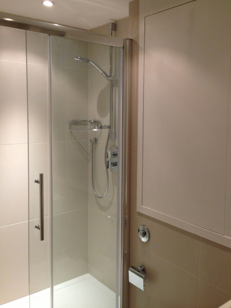 Exemple d'une petite douche en alcôve tendance avec un lavabo suspendu, WC suspendus, un carrelage beige, des carreaux de porcelaine, un mur blanc et un sol en carrelage de porcelaine.