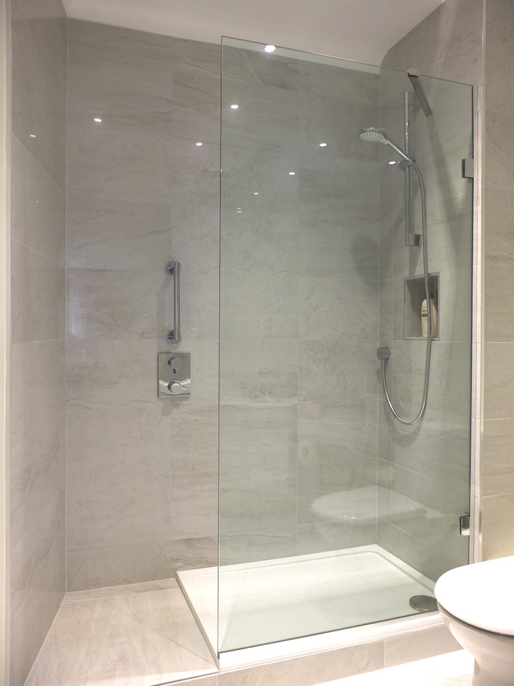 Foto på ett mellanstort funkis en-suite badrum, med en öppen dusch, grå kakel, porslinskakel, grå väggar, klinkergolv i porslin och ett väggmonterat handfat