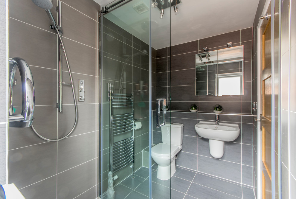 Small contemporary shower room bathroom in Manchester with a wall mounted toilet, grey tiles and ceramic flooring.