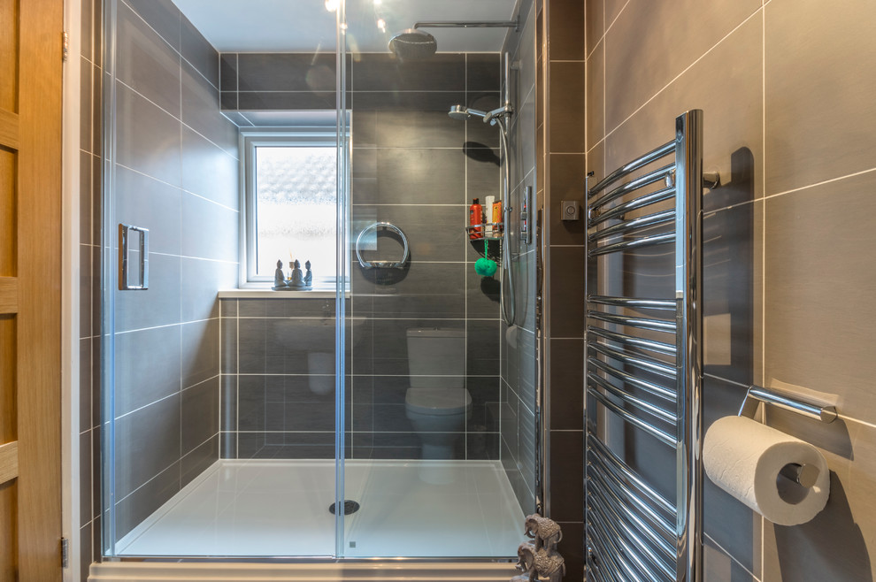 Design ideas for a small contemporary shower room bathroom in Manchester with a wall mounted toilet, grey tiles and ceramic flooring.