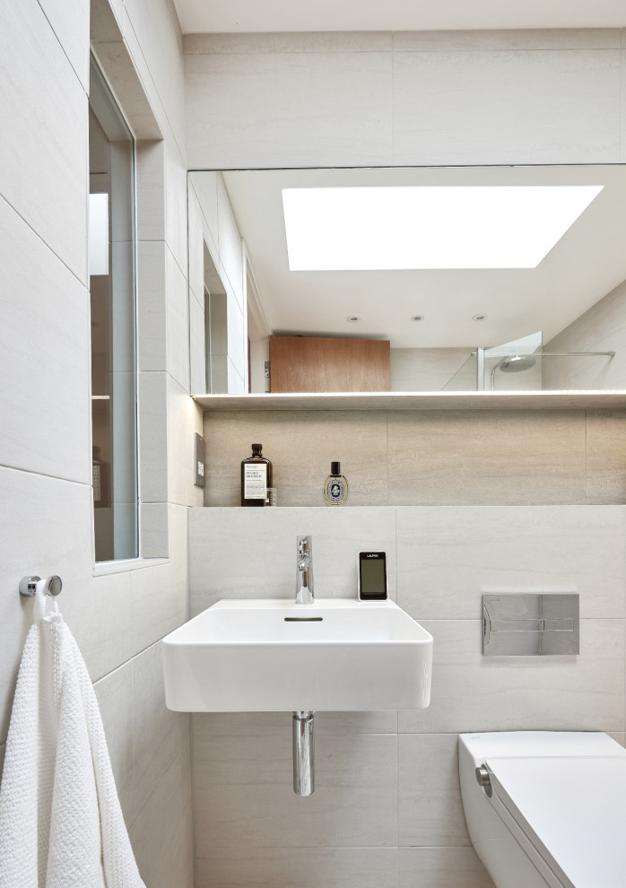 Bild på ett litet funkis badrum med dusch, med våtrum, en vägghängd toalettstol, grå kakel, porslinskakel, grå väggar, klinkergolv i porslin, ett väggmonterat handfat, grått golv och med dusch som är öppen