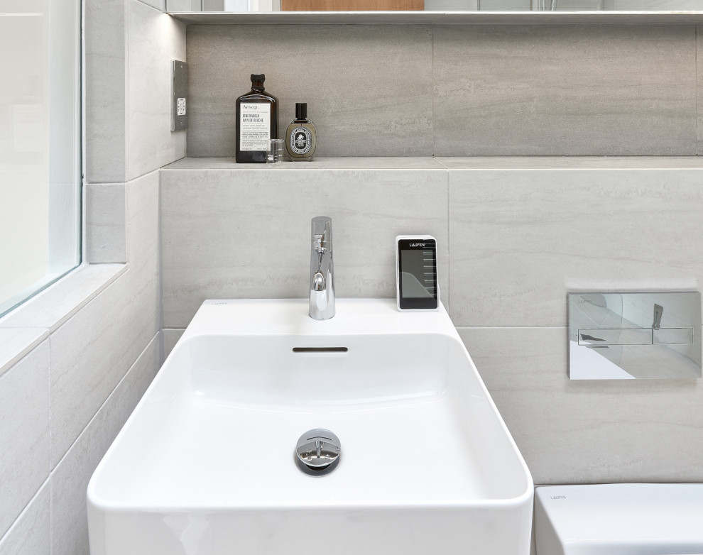 Idéer för att renovera ett litet funkis badrum med dusch, med våtrum, en vägghängd toalettstol, grå kakel, porslinskakel, grå väggar, klinkergolv i porslin, ett väggmonterat handfat, grått golv och med dusch som är öppen