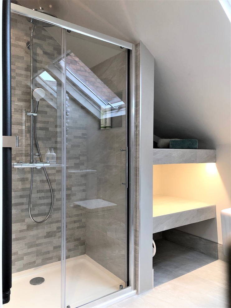 Exemple d'une petite salle de bain tendance avec WC séparés, un carrelage gris, des carreaux de porcelaine, un mur gris, un sol en carrelage de porcelaine, un lavabo suspendu, un sol gris et une cabine de douche à porte coulissante.
