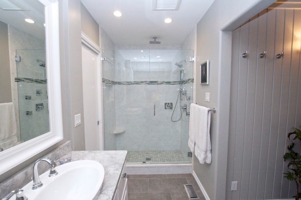 Cette photo montre une salle de bain chic de taille moyenne avec un placard avec porte à panneau surélevé, des portes de placard blanches, WC à poser, des carreaux en allumettes, un mur gris, un lavabo posé, un carrelage gris, un sol en carrelage de céramique et un plan de toilette en granite.