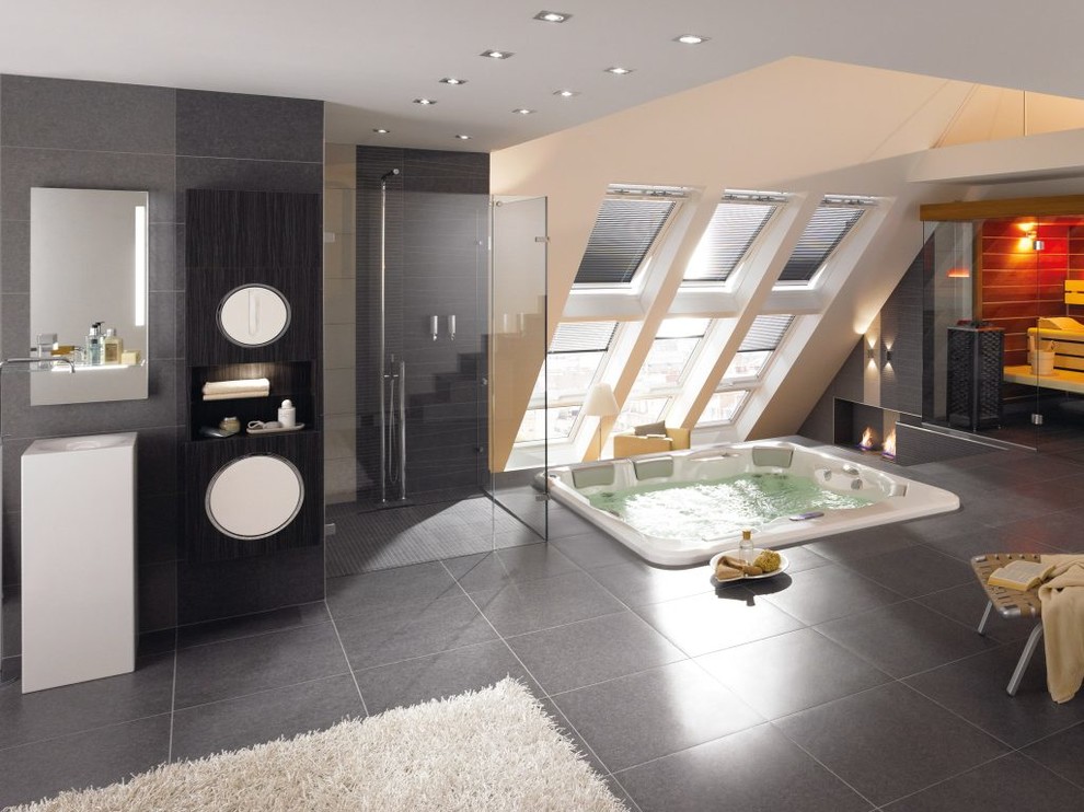 Foto di una stanza da bagno minimal con lavabo a colonna, vasca idromassaggio, doccia ad angolo e piastrelle grigie