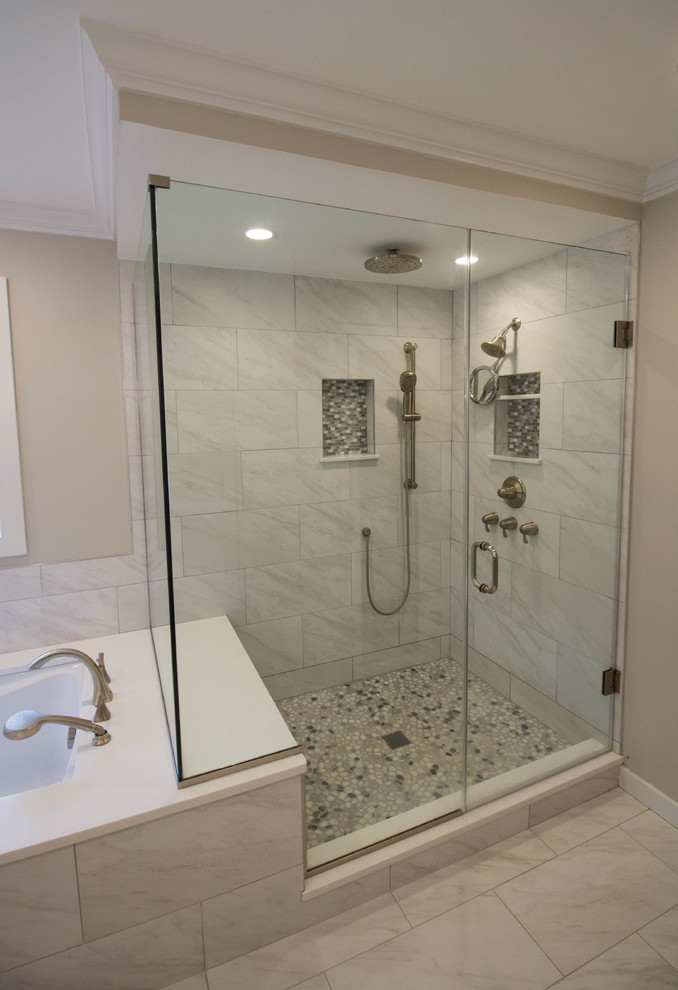 Стильный дизайн: главная ванная комната среднего размера в стиле неоклассика (современная классика) с угловым душем, душем с распашными дверями, полновстраиваемой ванной, белой плиткой, керамогранитной плиткой и полом из галечной плитки - последний тренд