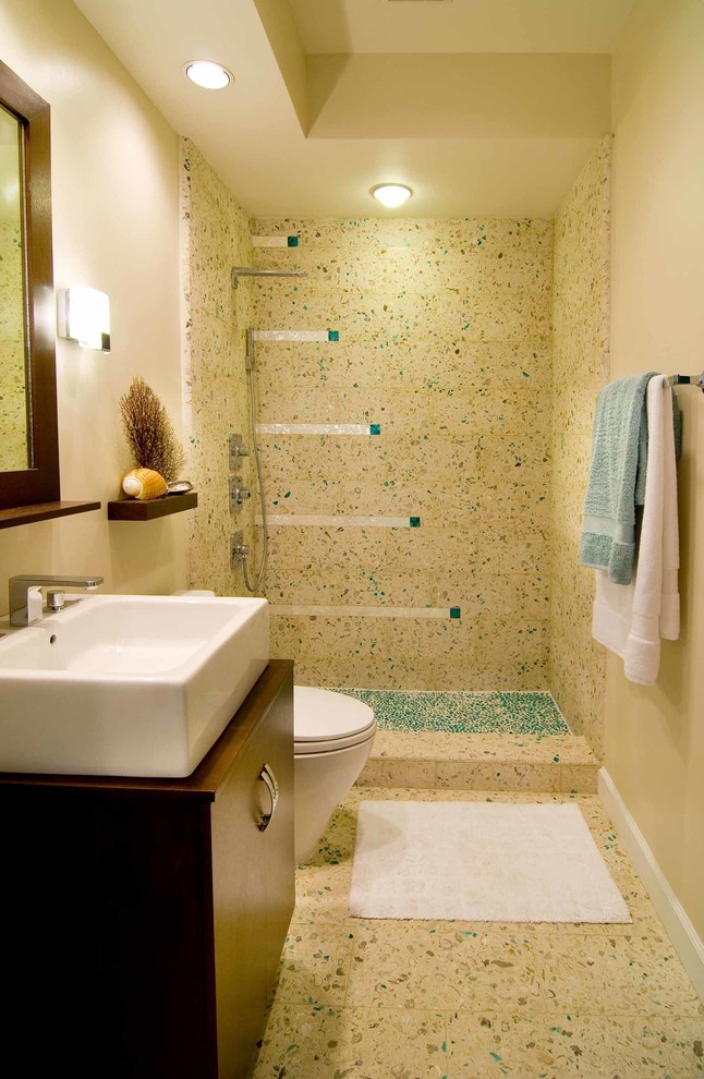 Cette photo montre une petite salle de bain moderne en bois foncé avec une vasque, un placard à porte plane, WC séparés, un carrelage multicolore, des carreaux de béton, sol en béton ciré et un mur beige.