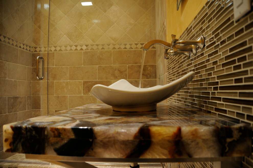 На фото: ванная комната среднего размера в восточном стиле с открытыми фасадами, душем в нише, унитазом-моноблоком, каменной плиткой, желтыми стенами, полом из керамогранита, душевой кабиной, настольной раковиной и столешницей из оникса