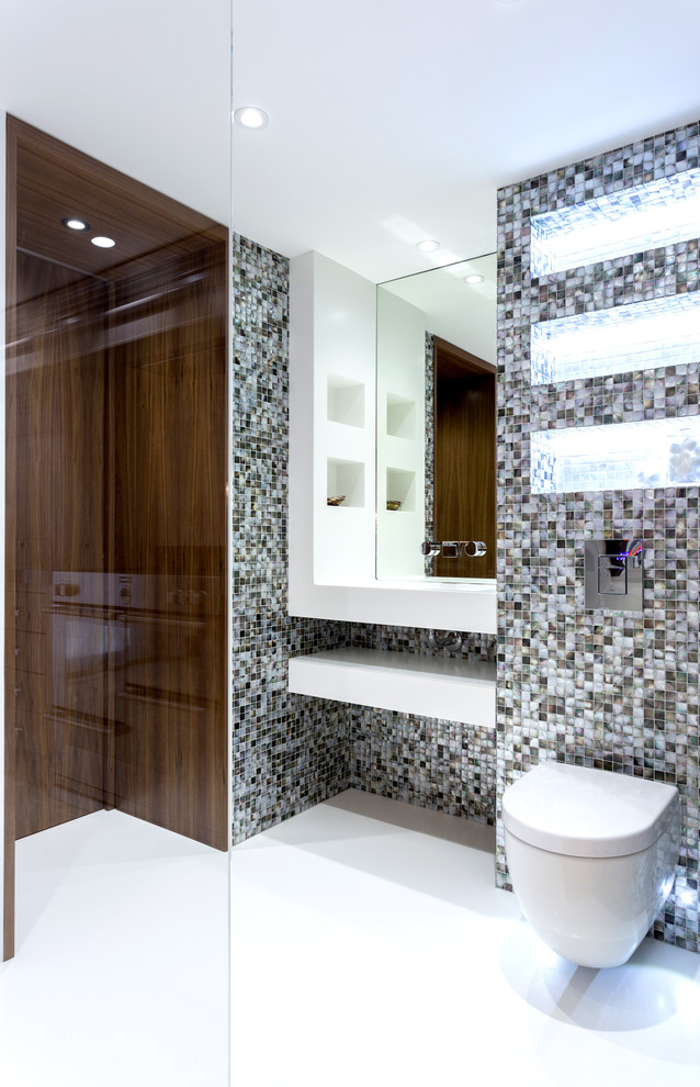 Example of a small 3/4 multicolored tile doorless shower design in London with white cabinets and a wall-mount toilet
