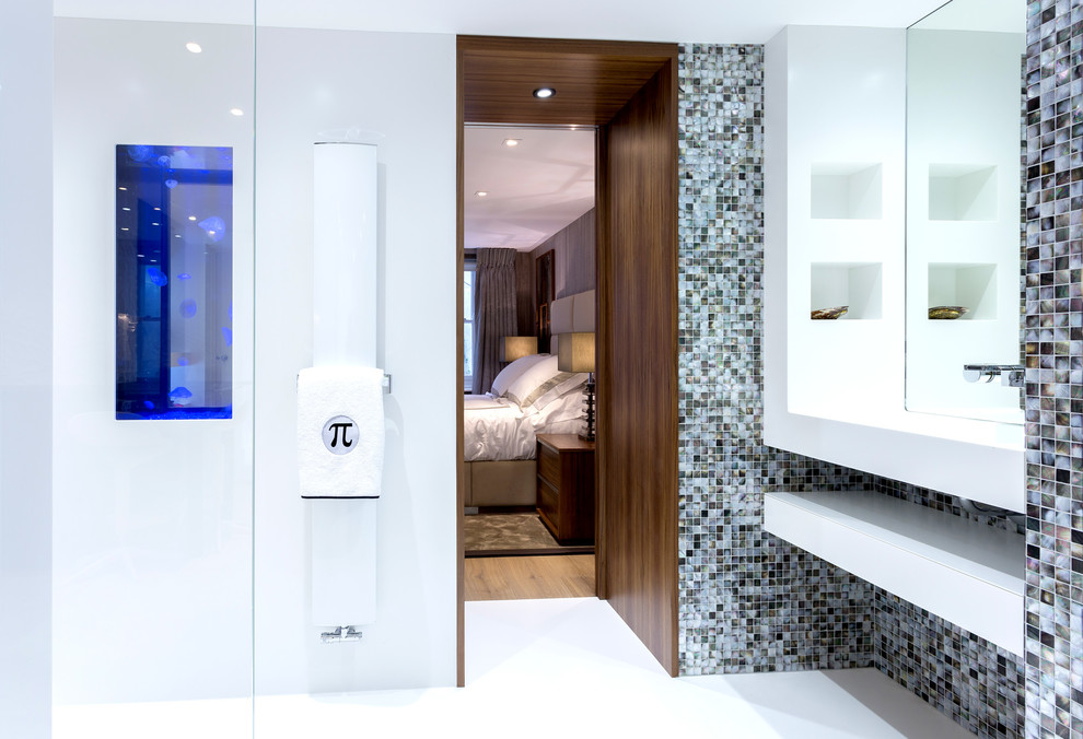 Idée de décoration pour une salle d'eau design avec une douche ouverte, WC suspendus, un carrelage multicolore, mosaïque et un mur blanc.