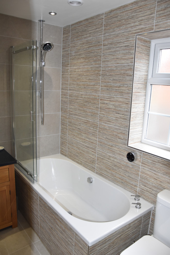 Immagine di una stanza da bagno moderna con WC a due pezzi, piastrelle grigie, piastrelle in ceramica, pavimento in gres porcellanato, lavabo a colonna e pavimento grigio