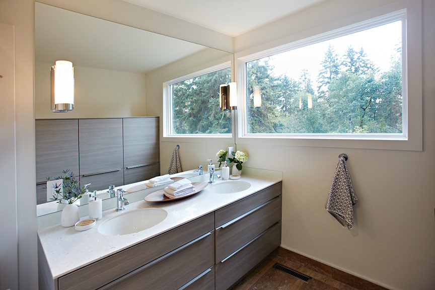 Large contemporary ensuite bathroom in Edmonton with flat-panel cabinets, solid surface worktops, a submerged bath, a corner shower, a submerged sink, medium hardwood flooring, brown floors, medium wood cabinets and beige walls.