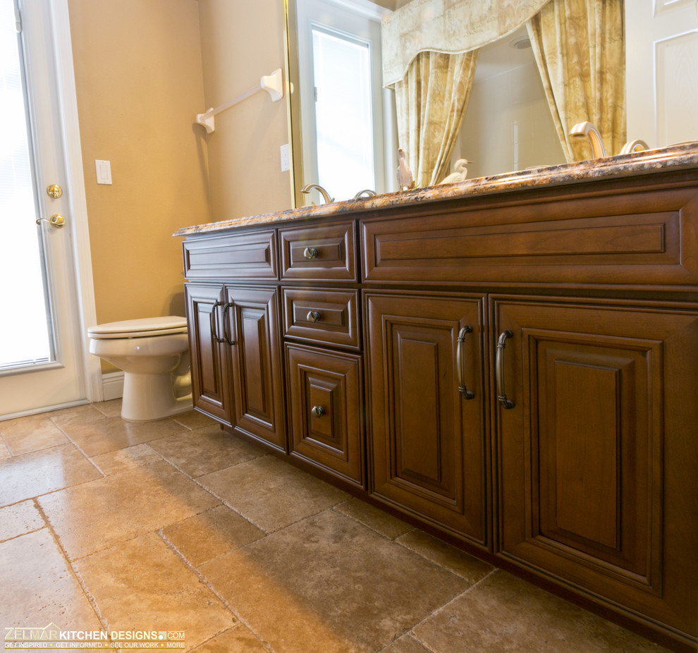 This is an example of a large classic ensuite bathroom in Orlando with raised-panel cabinets, dark wood cabinets, granite worktops, a walk-in shower, beige tiles, stone tiles and travertine flooring.