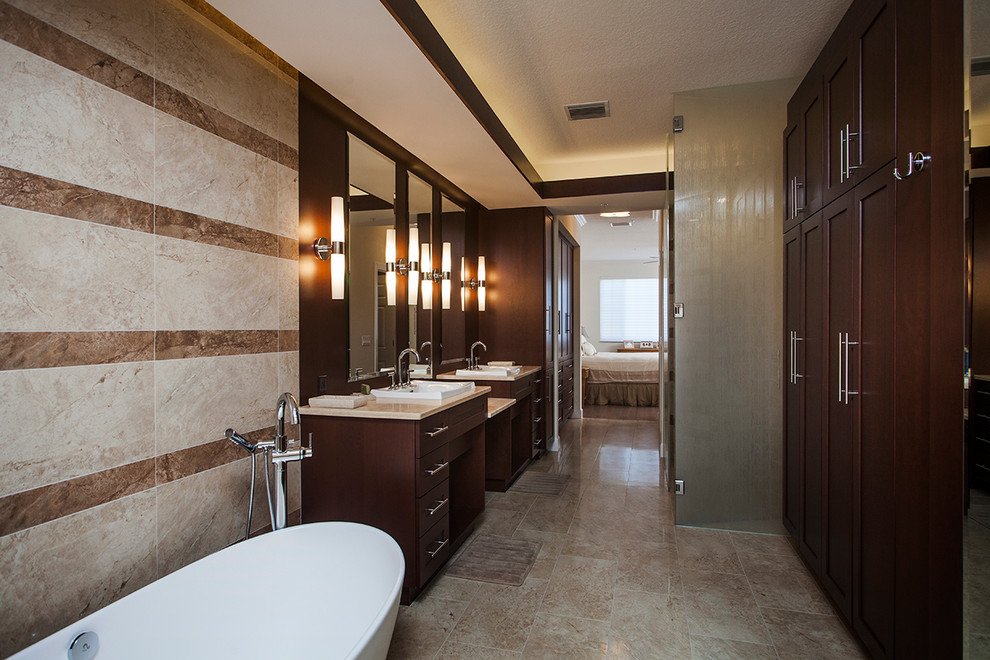 Exemple d'une salle de bain principale chic en bois foncé avec un lavabo posé, un placard avec porte à panneau encastré, un plan de toilette en marbre, une baignoire indépendante, une douche ouverte, un carrelage beige, un carrelage de pierre et un sol en travertin.
