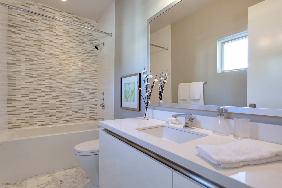Свежая идея для дизайна: ванная комната среднего размера в современном стиле с плоскими фасадами, белыми фасадами, душем в нише, серыми стенами, мраморным полом, душевой кабиной, врезной раковиной, столешницей из искусственного камня, белым полом, белой столешницей, ванной в нише, разноцветной плиткой, удлиненной плиткой и шторкой для ванной - отличное фото интерьера
