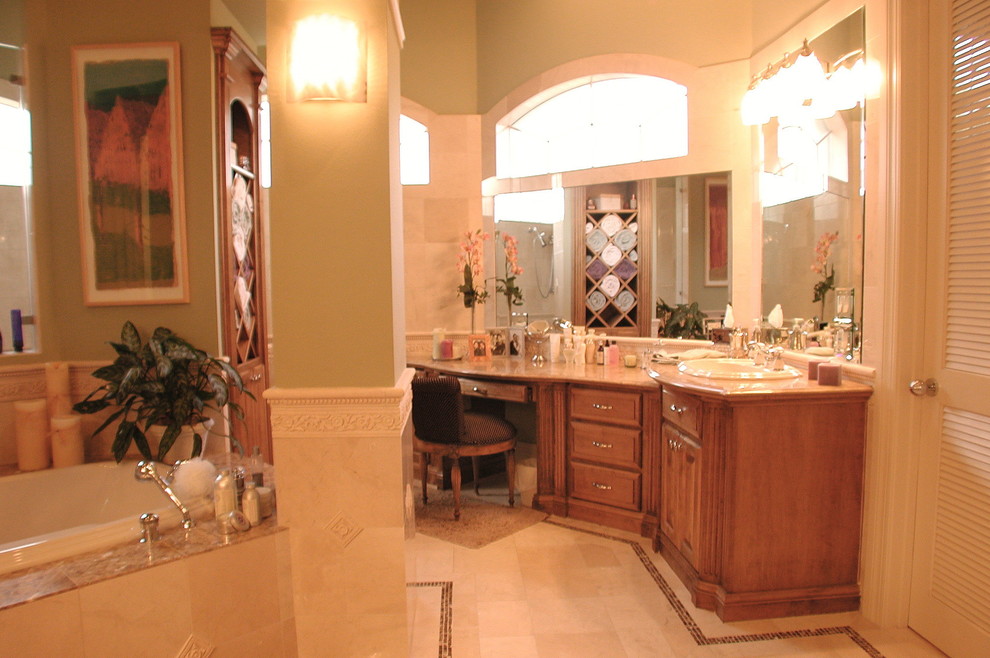 Bild på ett stort funkis en-suite badrum, med ett nedsänkt handfat, luckor med upphöjd panel, skåp i mellenmörkt trä, granitbänkskiva, ett platsbyggt badkar, en dubbeldusch, en bidé, beige kakel, stenkakel, gröna väggar och travertin golv