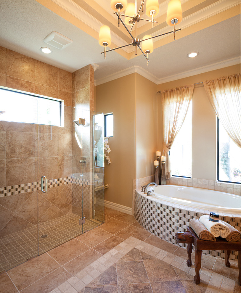 Inspiration for a tropical master limestone floor and beige floor bathroom remodel in Orlando with shaker cabinets, medium tone wood cabinets, beige walls and a hinged shower door
