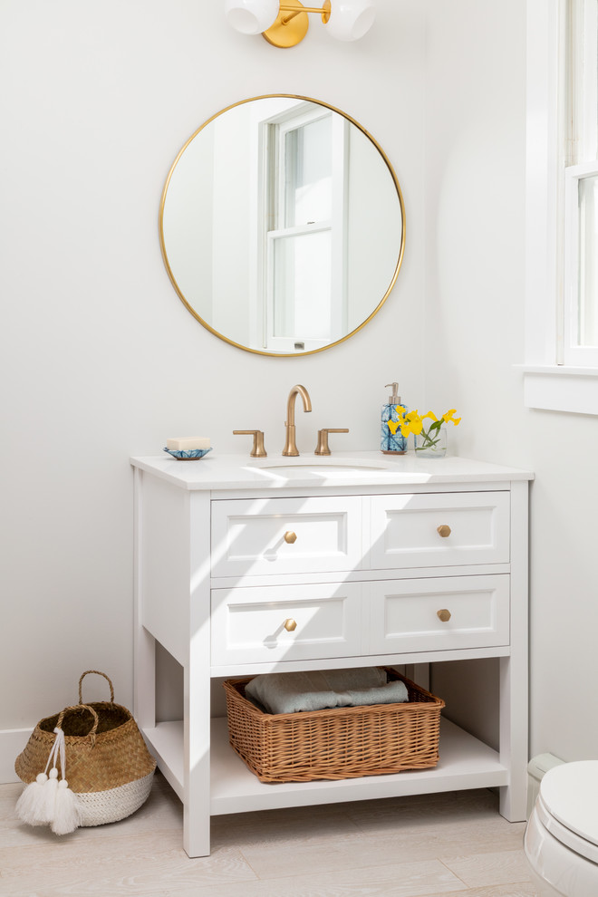 Bathroom - coastal beige floor bathroom idea in New York with furniture-like cabinets, white cabinets, white walls, an undermount sink and white countertops