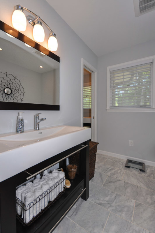 На фото: ванная комната в современном стиле с открытыми фасадами, черными фасадами, серой плиткой, монолитной раковиной, отдельно стоящей ванной, синими стенами и полом из керамогранита с