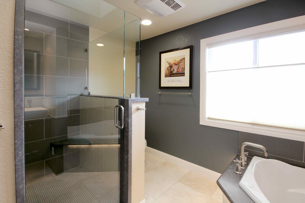 Inspiration for a medium sized contemporary ensuite bathroom in San Francisco with recessed-panel cabinets, dark wood cabinets, a corner bath, a corner shower, a two-piece toilet, blue tiles, porcelain tiles, blue walls, limestone flooring, a vessel sink and limestone worktops.