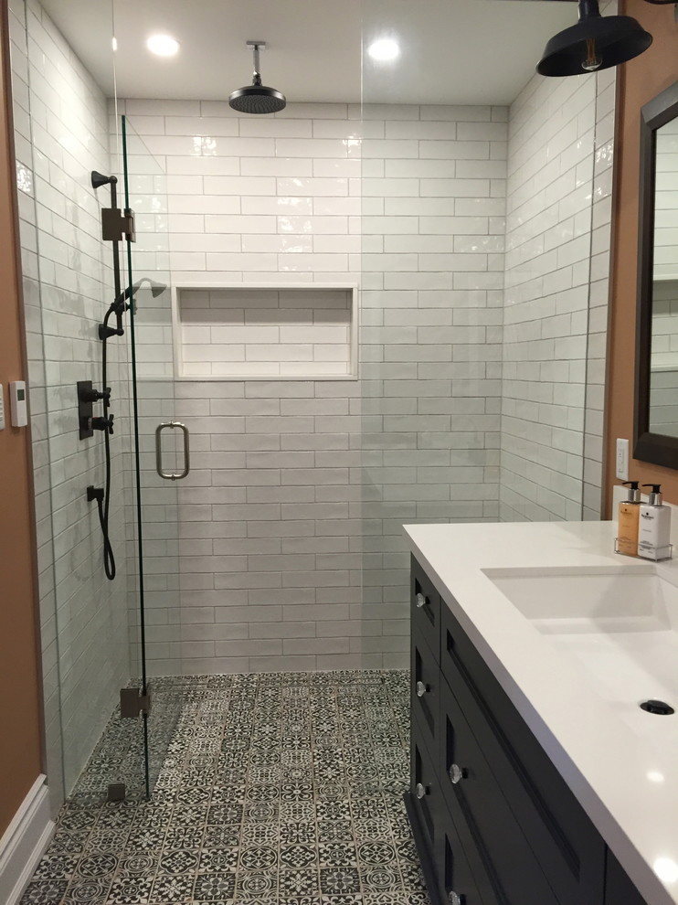 Ispirazione per una piccola stanza da bagno con doccia design con ante con riquadro incassato, ante nere, doccia alcova, pareti arancioni, pavimento con piastrelle in ceramica, lavabo sottopiano e top in superficie solida