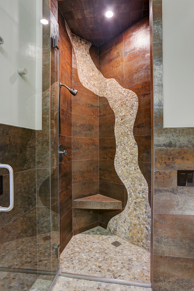 Exemple d'une grande douche en alcôve principale tendance avec un carrelage beige, un carrelage marron, un carrelage de pierre, un mur gris, un sol en galet, un sol beige et une cabine de douche à porte battante.