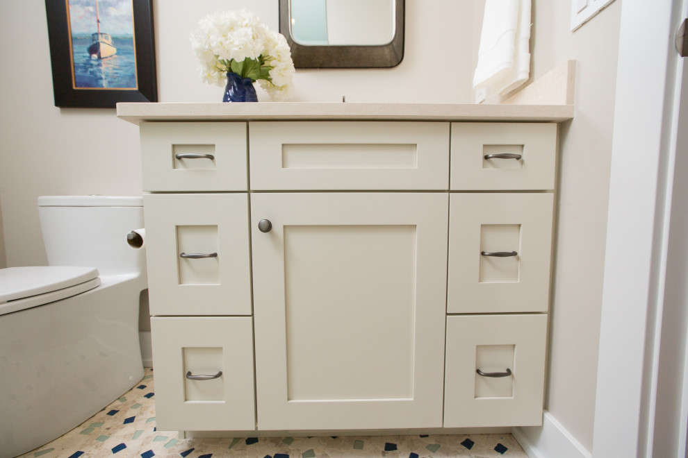 Пример оригинального дизайна: ванная комната среднего размера с фасадами в стиле шейкер, белыми фасадами, душем в нише, унитазом-моноблоком, зеленой плиткой, стеклянной плиткой, бежевыми стенами, полом из галечной плитки, душевой кабиной, врезной раковиной, столешницей из искусственного кварца, бежевым полом, душем с распашными дверями, бежевой столешницей, нишей, тумбой под одну раковину и встроенной тумбой