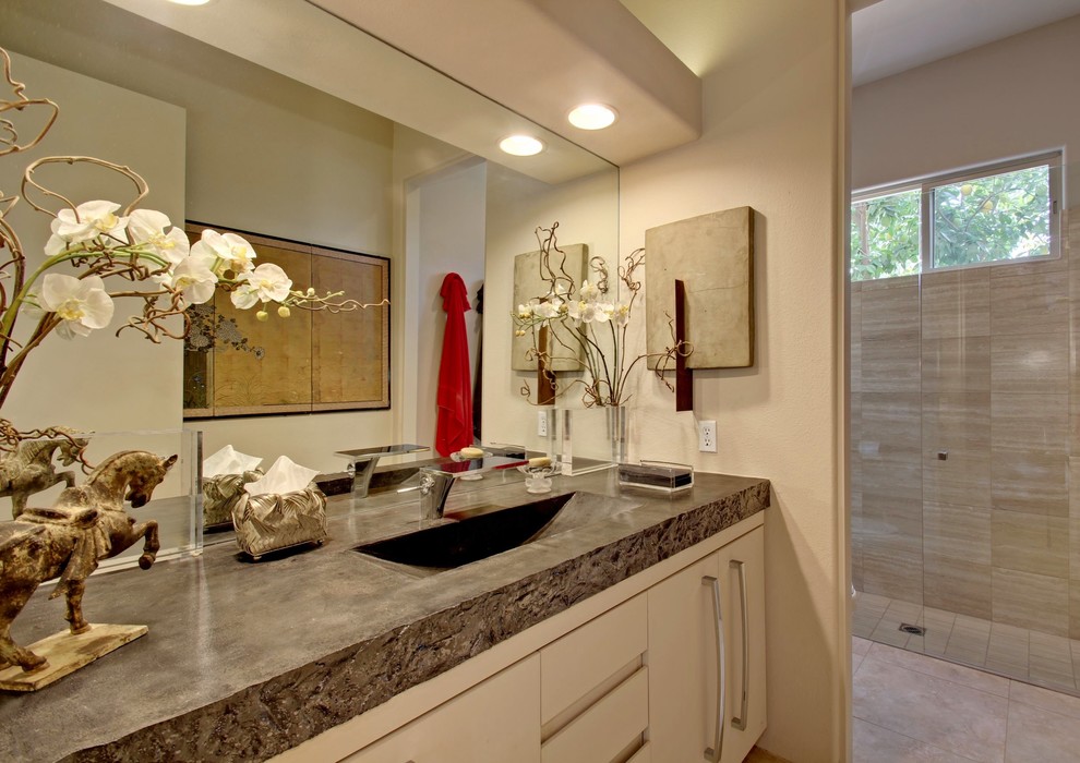 Foto på ett funkis badrum, med ett integrerad handfat, släta luckor, beige kakel, bänkskiva i betong och vita skåp