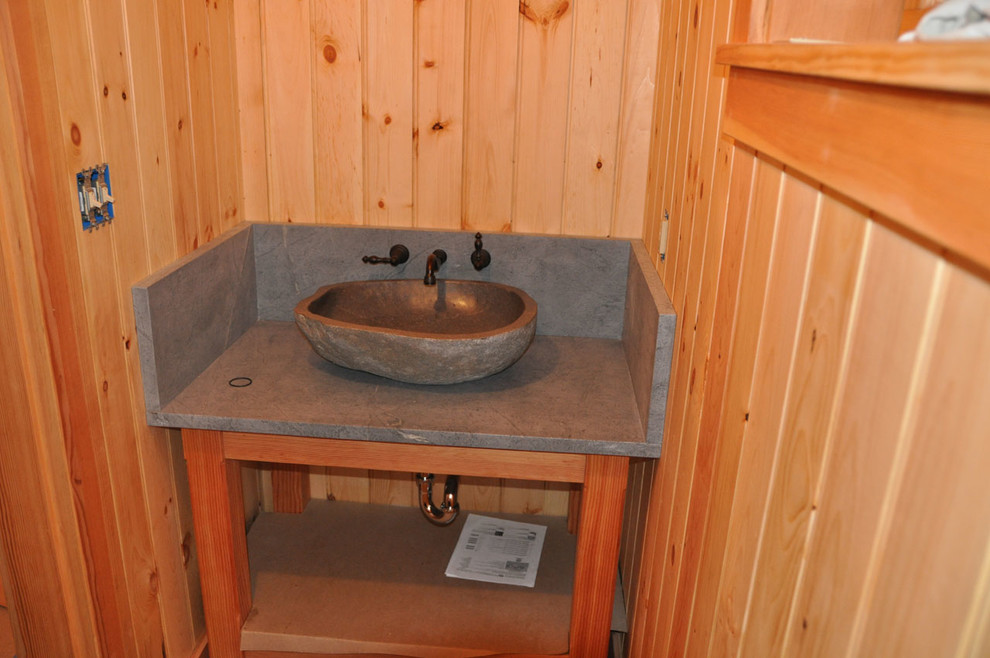 Kleines Uriges Duschbad mit verzierten Schränken, hellen Holzschränken, Toilette mit Aufsatzspülkasten, grauen Fliesen, Steinplatten, beiger Wandfarbe, hellem Holzboden, Aufsatzwaschbecken und Mineralwerkstoff-Waschtisch in Boston