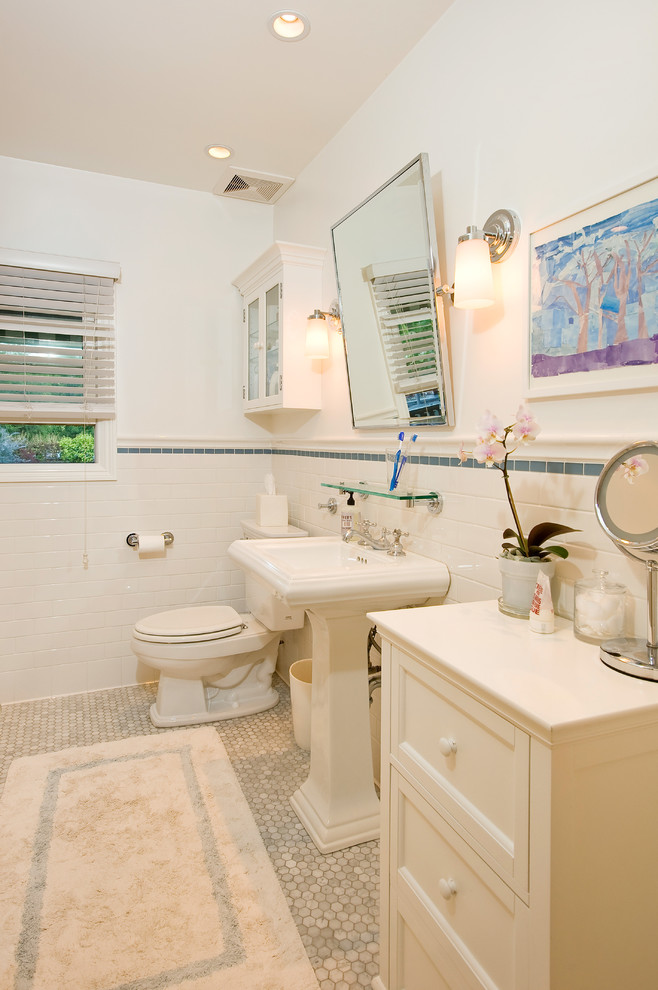 Immagine di una stanza da bagno classica con lavabo a colonna, ante con riquadro incassato, ante bianche, WC a due pezzi e piastrelle bianche