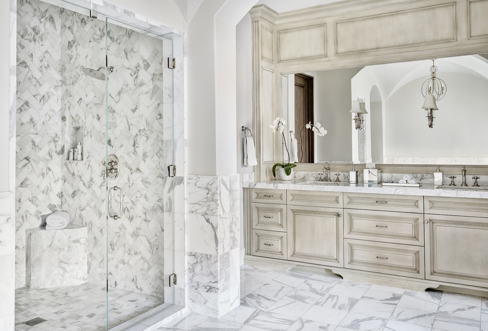 Immagine di una grande stanza da bagno padronale mediterranea con ante con bugna sagomata, ante in legno chiaro, doccia alcova, piastrelle bianche, piastrelle di marmo, pareti bianche, pavimento in marmo, lavabo sottopiano, top in marmo e pavimento bianco
