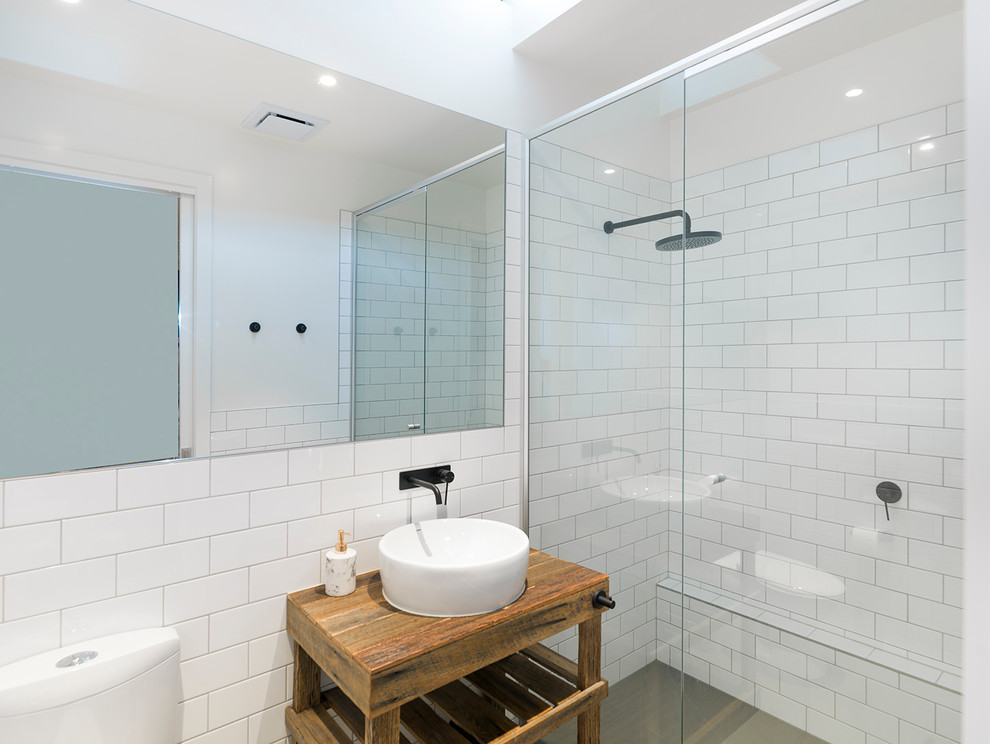Modelo de cuarto de baño actual con ducha empotrada, baldosas y/o azulejos blancos, baldosas y/o azulejos de cemento, paredes blancas, aseo y ducha y lavabo sobreencimera