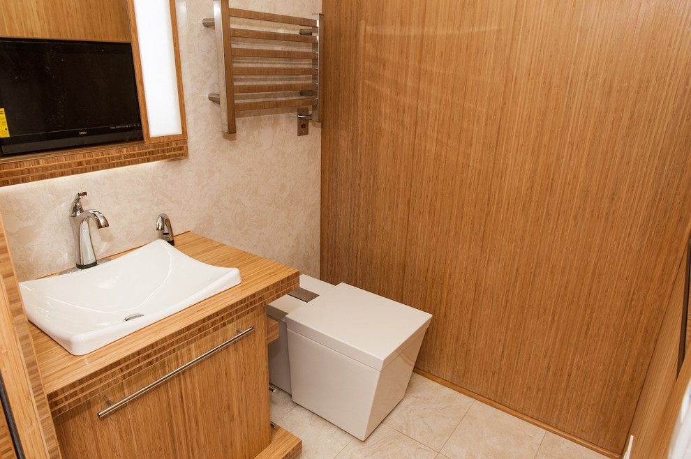 This is an example of a small world-inspired bathroom in DC Metro with a built-in sink, flat-panel cabinets, medium wood cabinets, wooden worktops, a one-piece toilet, beige tiles, porcelain tiles, beige walls and porcelain flooring.