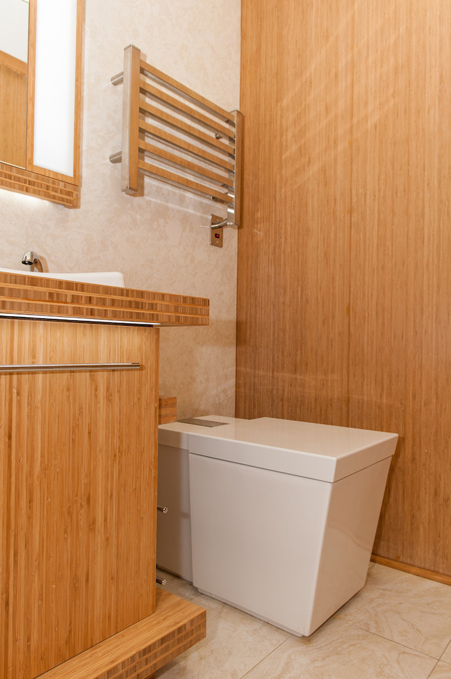 Design ideas for a small world-inspired bathroom in DC Metro with a built-in sink, flat-panel cabinets, medium wood cabinets, wooden worktops, a one-piece toilet, beige tiles, porcelain tiles, beige walls and porcelain flooring.