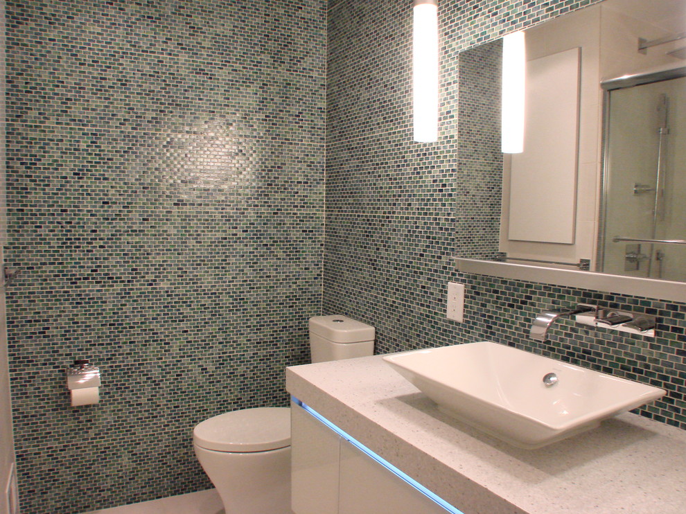 Inredning av ett modernt mellanstort badrum, med släta luckor, vita skåp, ett badkar i en alkov, en dusch/badkar-kombination, en toalettstol med hel cisternkåpa, blå kakel, grön kakel, mosaik, flerfärgade väggar, ett fristående handfat, klinkergolv i porslin och beiget golv