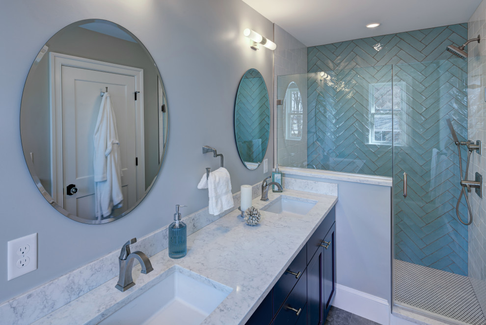 Medium sized traditional ensuite bathroom in DC Metro with shaker cabinets, blue cabinets, an alcove shower, a one-piece toilet, blue tiles, ceramic tiles, white walls, porcelain flooring, a submerged sink, engineered stone worktops, grey floors, a hinged door, white worktops, a shower bench, double sinks and a freestanding vanity unit.