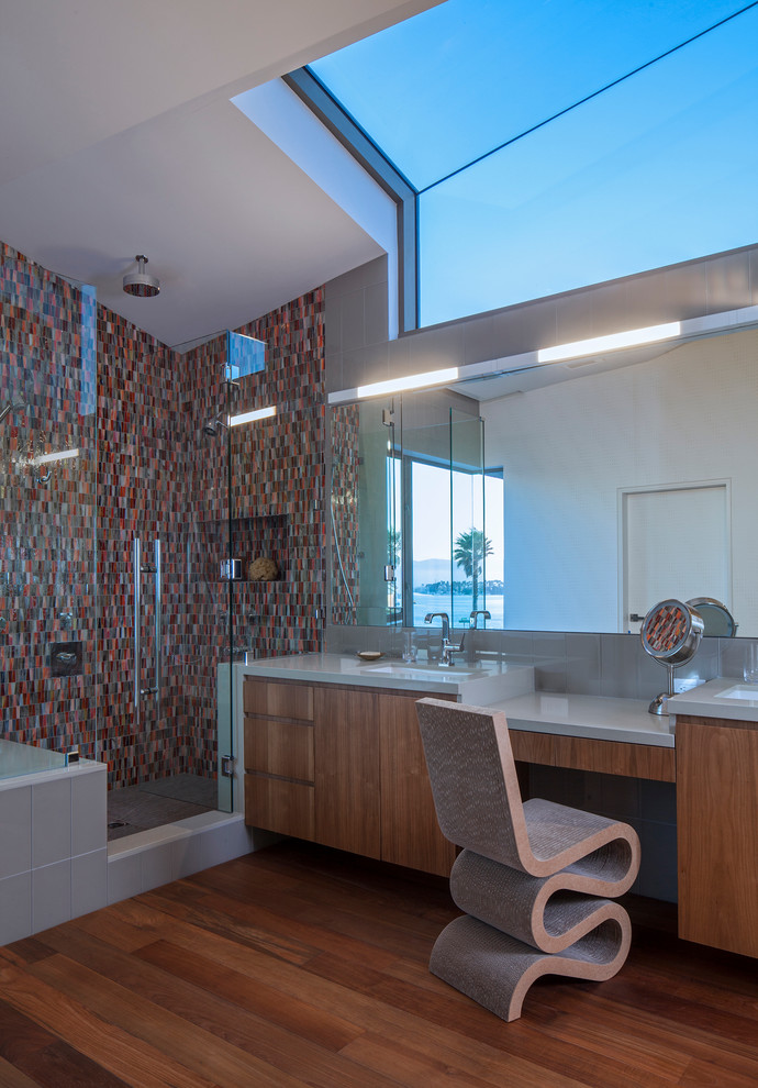 Large contemporary ensuite bathroom in Los Angeles with flat-panel cabinets, medium wood cabinets, a submerged bath, an alcove shower, brown tiles, orange tiles, red tiles, mosaic tiles, beige walls, medium hardwood flooring, a submerged sink, engineered stone worktops, brown floors and a hinged door.