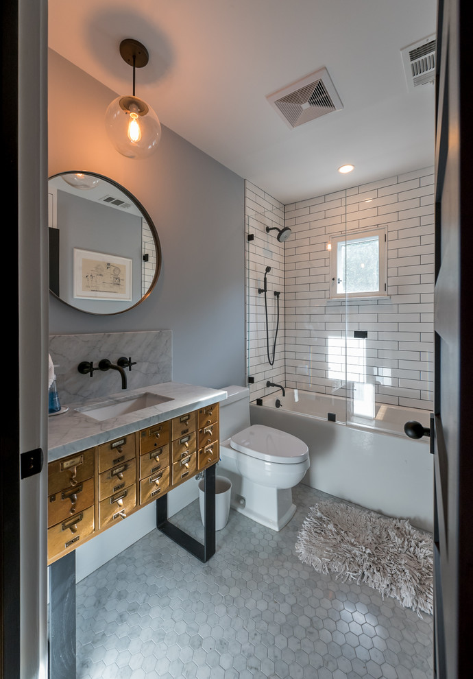 Стильный дизайн: главная ванная комната среднего размера в стиле кантри с фасадами островного типа, искусственно-состаренными фасадами, ванной в нише, душем в нише, унитазом-моноблоком, белой плиткой, керамической плиткой, серыми стенами, мраморным полом, врезной раковиной, мраморной столешницей, серым полом и душем с распашными дверями - последний тренд